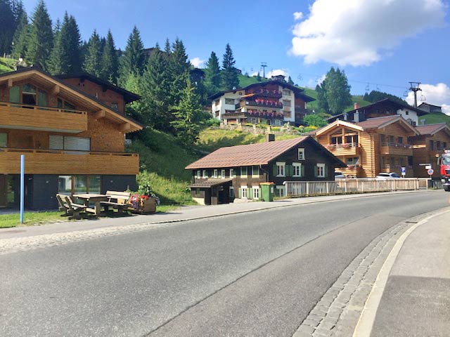 Surroundings of Appart Andrea holiday apartments in Lech with a road and green meadows in summer